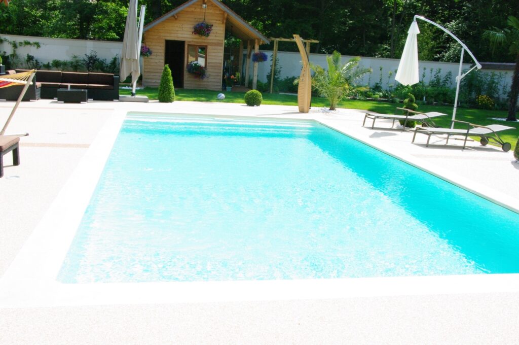 Piscine terminée avec liner clair et plage blanche